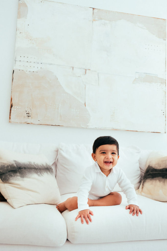 Young girl with a red bow in her hair, expressing delight in a field of vibrant flowers.