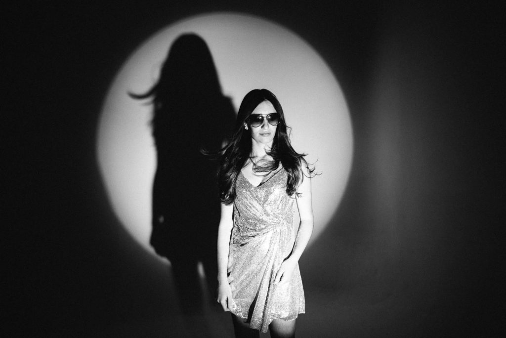 woman in a dress with dramatic shadow lighting, creating a stylish portrait look