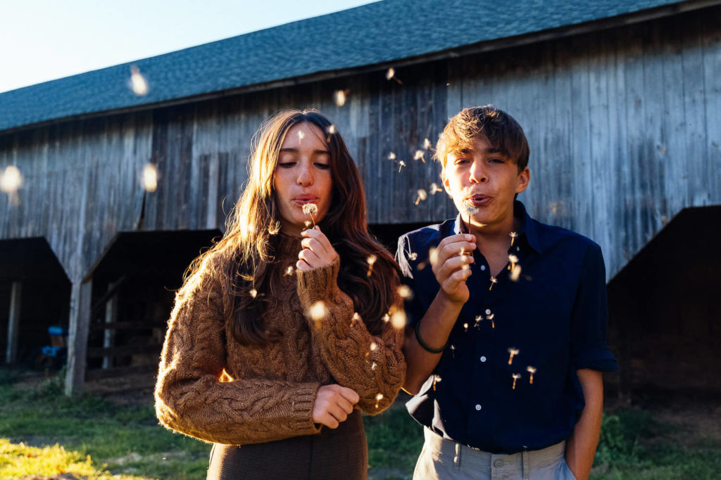 toddler in red dress playing with flowers, natural fall setting, kids portrait session
