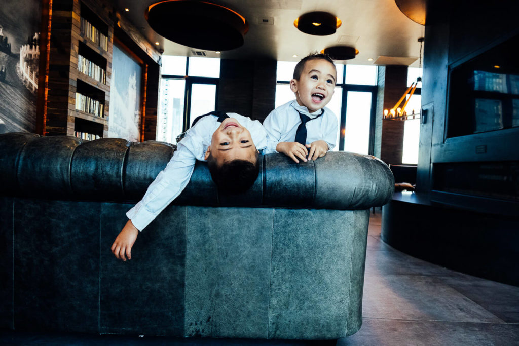Boy wearing a colorful star-patterned jacket, smiling brightly in front of a vibrant mural.