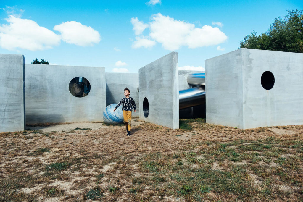Boy running through a modern outdoor play structure