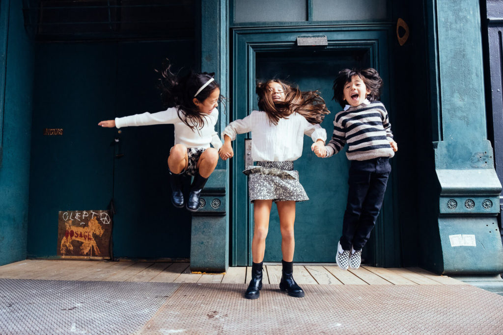 Kids jumping with excitement during a playful photography session in NYC.