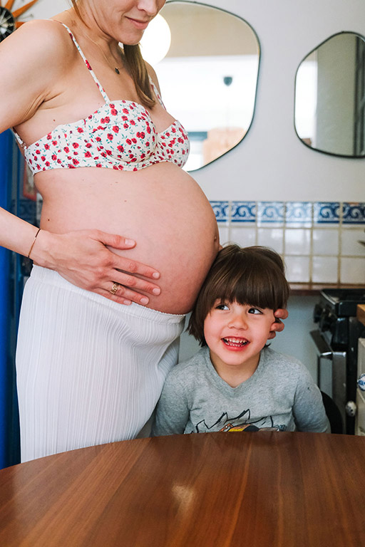 NYC maternity photography with sibling, pregnant mom and child in home kitchen session