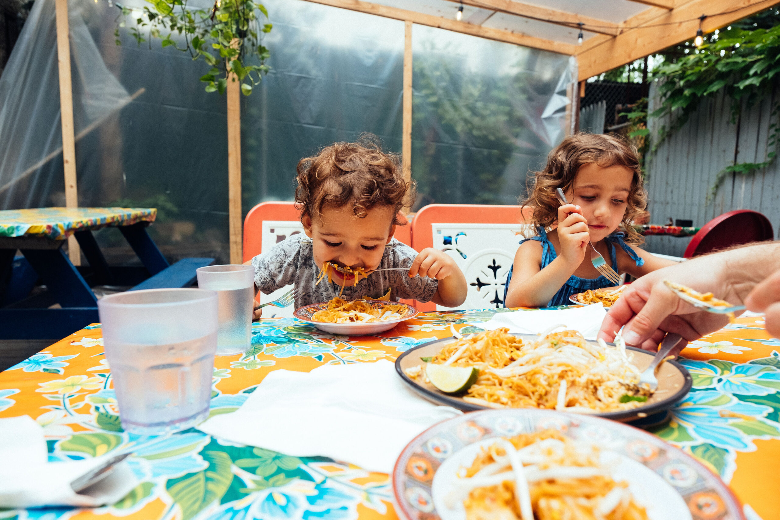 Two children eating at outdoor family restaurant in Brooklyn NYC